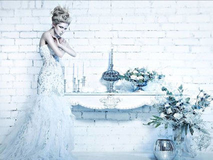 Beautiful girl in white dress in the image of the Snow Queen with a crown on her head. Picture taken in the studio with decorations