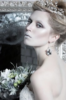 Beautiful girl in white dress in the image of the Snow Queen with a crown on her head. Picture taken in the studio with decorations