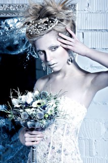 Beautiful girl in white dress in the image of the Snow Queen with a crown on her head. Picture taken in the studio with decorations