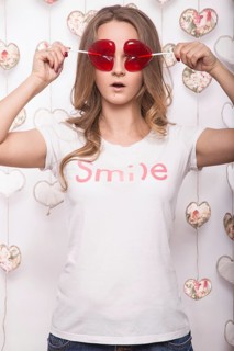 Valentines Day. Funny beautiful Woman holding candy in the form of heart. Beauty face. Picture taken in the studio with decorations