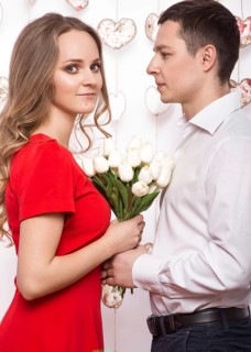 Beautiful young couple in love with a bouquet of flowers. Valentine's Day. Picture taken in the studio