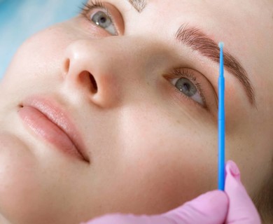 Permanent microblasting tattooing freckles to a woman in a beauty salon
