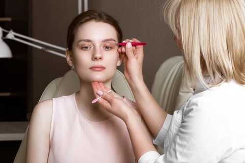 Permanent microblasting tattooing freckles to a woman in a beauty salon