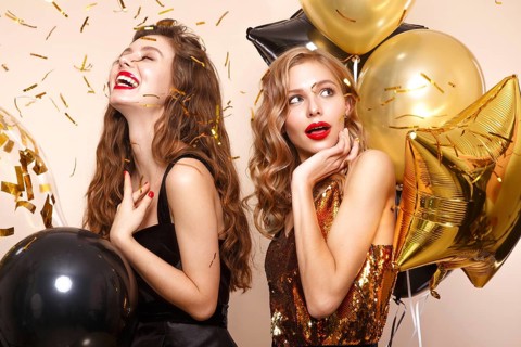 Beautiful young women in elegant evening dresses with festive balloons. Beauty face. Photo taken in the studio