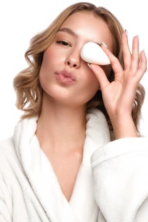 Beautiful tender young girl in a white coat with clean fresh skin posing in front of the camera. Beauty face. Skin care. Photo taken in studio on a white isolate background
