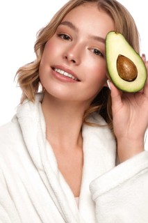 Beautiful tender young girl in a white coat with clean fresh skin posing in front of the camera. Beauty face. Skin care. Photo taken in studio on a white isolate background