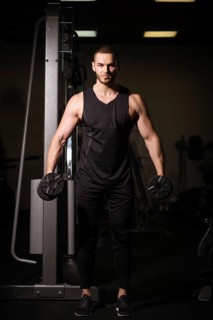 Sporty sexy men with great abdominal muscles in black sportswear working out in the gym