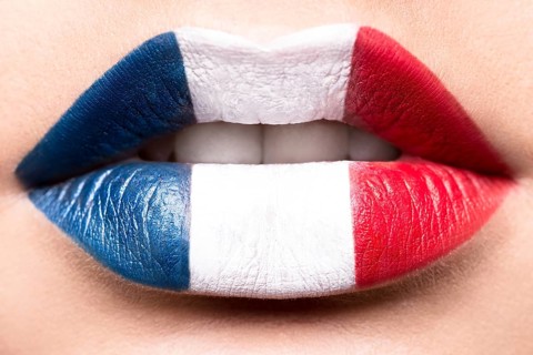 Female lips close up with a picture of the flag of France. Blue