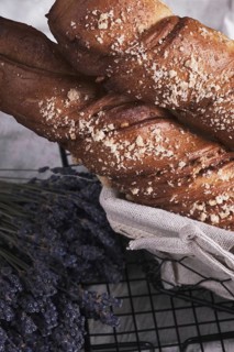 White bread in a basket and lavender flowers in vintage style