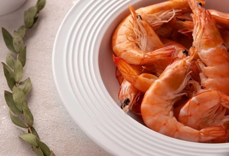 Boiled shrimps in a white plate with lemon