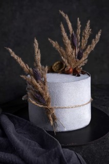 Rustic cake on a dark background with dry flowers