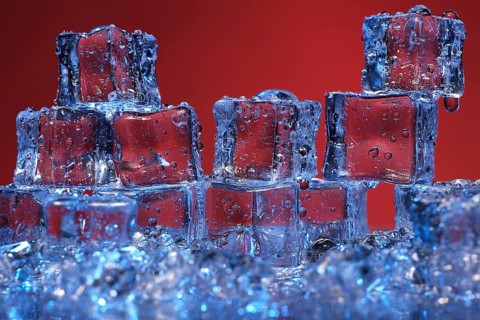 Transparent cold ice cubes on a red background