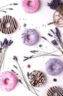 Sweet multicolored donuts on a white background with lavender flowers
