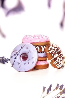 Sweet multicolored donuts on a white background with lavender flowers