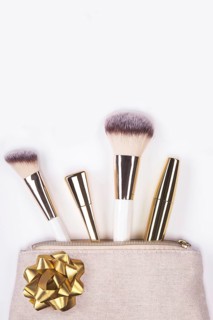 Set of brushes and cosmetic products in a cosmetic bag on a white background