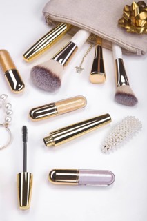 Set of brushes and cosmetic products in a cosmetic bag on a white background