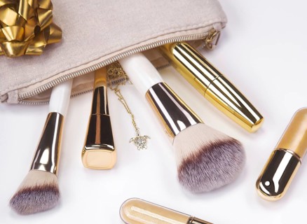 Set of brushes and cosmetic products in a cosmetic bag on a white background