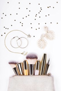 Set of brushes and cosmetic products in a cosmetic bag on a white background