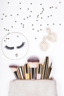 Set of brushes and cosmetic products in a cosmetic bag on a white background
