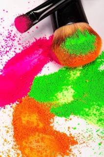 Cheek brush with neon cosmetic powder colorful pile and isolated on white background