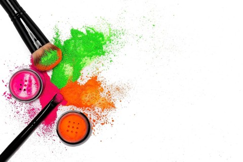 Cheek brush with neon cosmetic powder colorful pile and isolated on white background