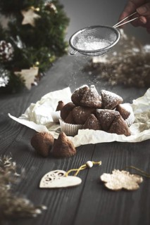 Simple Christmas truffle candy on a wooden background with plant branches