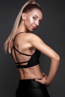 Sports girl with pumped muscles in a tracksuit