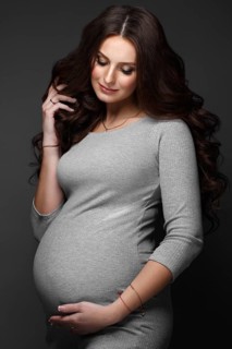 Beautiful pregnant woman in a gray dress