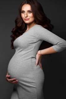 Beautiful pregnant woman in a gray dress