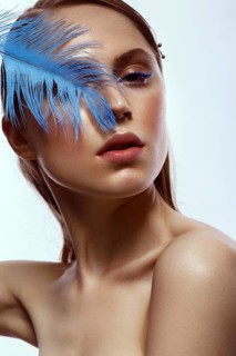 Beautiful tanned girl with creative make-up and blue eyelashes