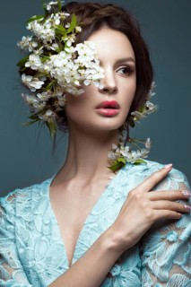 Beautiful brunette girl in blue dress with a gentle romantic make-up