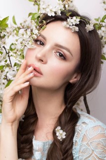 Beautiful brunette girl in blue dress with a gentle romantic make-up