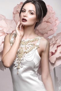 Beautiful girl with classic make-up and hairstyle in delicate Underwear with large flowers on background. beauty face. Photos shot in studio