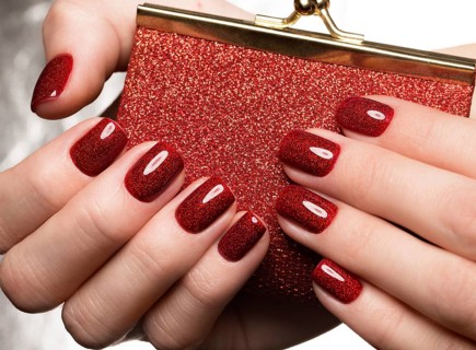 Bright festive red manicure on female hands. Nails design