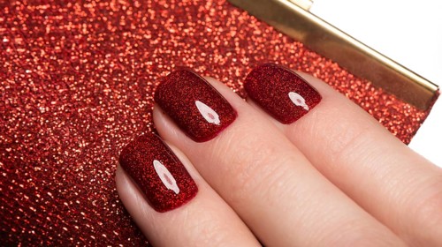 Bright festive red manicure on female hands. Nails design