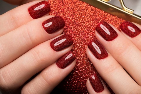 Bright festive red manicure on female hands. Nails design