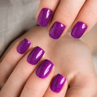 Bright festive purple manicure on female hands. Nails design