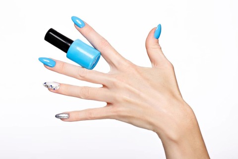 Beautiful summer blue manicure on female hand with nail polish. Close-up. Picture taken in the studio