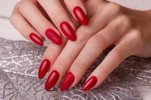 Bright festive red manicure on female hands. Nails design