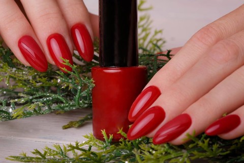 Bright festive red manicure on female hands. Nails design