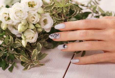 Gentle neat manicure on female hands on a background of flowers. Nail design