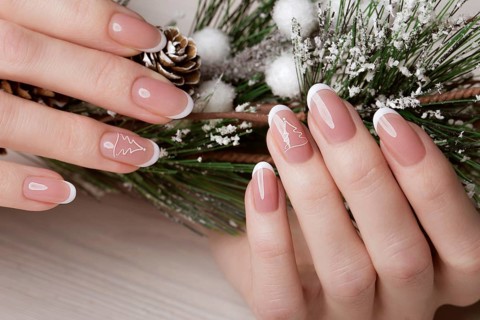 Snow White manicure on female hands. Winter nail design. Picture taken in the studio on a background of wool
