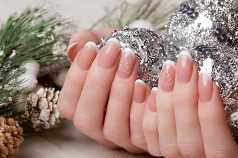 Snow White manicure on female hands. Winter nail design. Picture taken in the studio on a background of wool