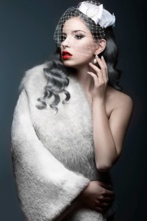 Elegant beautiful girl with silver curls and a veil. Winter image. Beauty face. Picture taken in the studio on a gray background