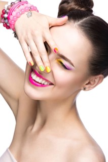 Beautiful girl in pink sunglasses with bright makeup and colorful nails. Beauty face. Picture taken in the studio on a white background