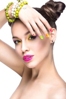 Beautiful girl in pink sunglasses with bright makeup and colorful nails. Beauty face. Picture taken in the studio on a white background