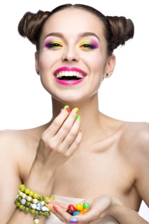 Beautiful girl in pink sunglasses with bright makeup and colorful nails. Beauty face. Picture taken in the studio on a white background