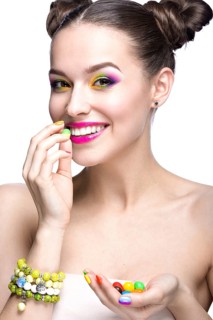 Beautiful girl in pink sunglasses with bright makeup and colorful nails. Beauty face. Picture taken in the studio on a white background