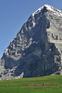 View from the Kleine Scheidegg at the notorious Eiger North Face with typical red train from the Jungfrau Railways in the Bernese Alps