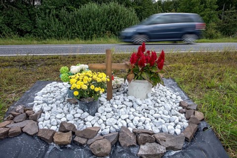 Memorial with cross for victims of road accident on country road